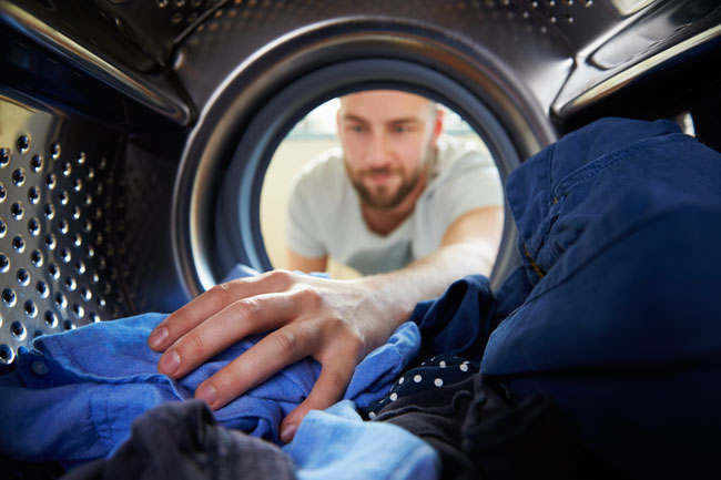 man taking clothes out of dryer